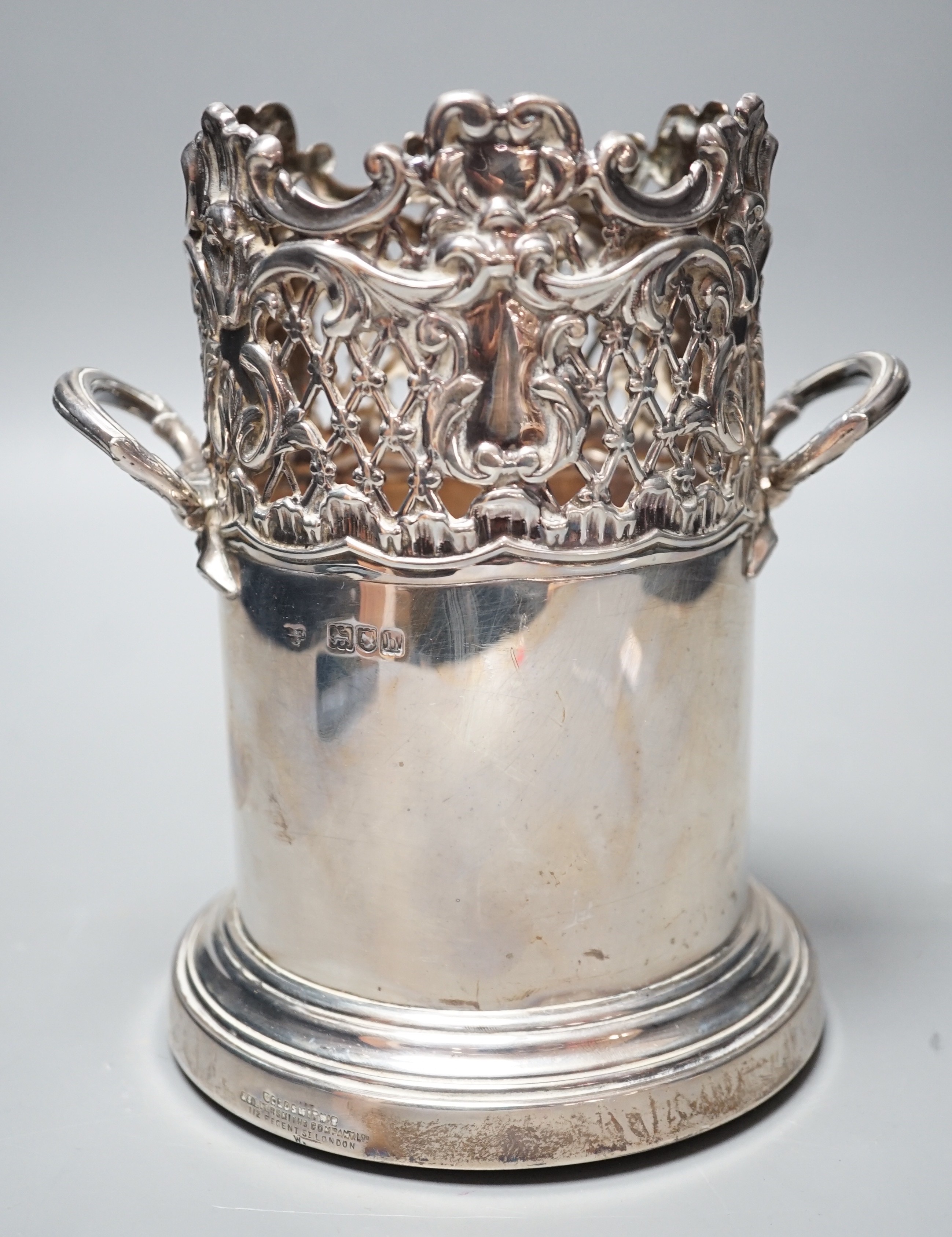 An Edwardian pierced silver mounted two handled syphon stand, by Goldsmiths & Silversmiths Co Ltd, London, 1903, 17.8cm, with turned wooden base.